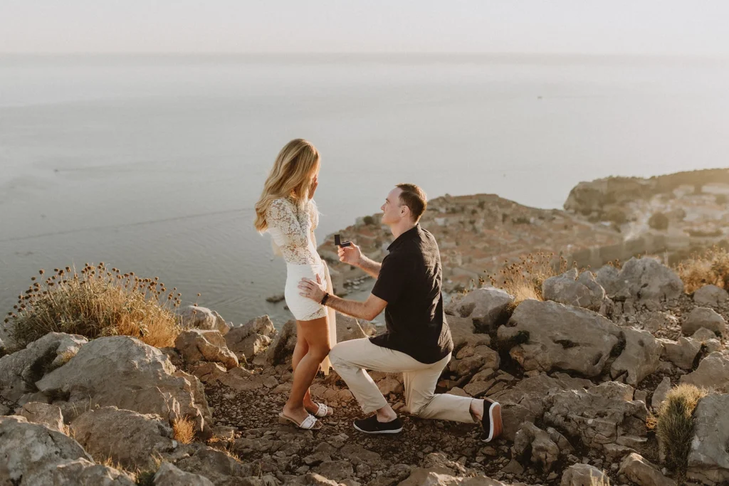 guy kneeling down and proposing his girlfriend above dubrovnik