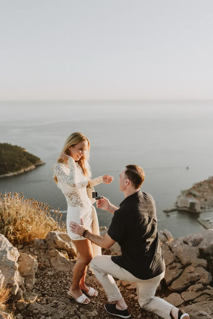 young guy proposing his girlfriend with sea view