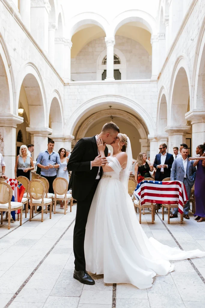 bride and groom kissing at the church, american flag