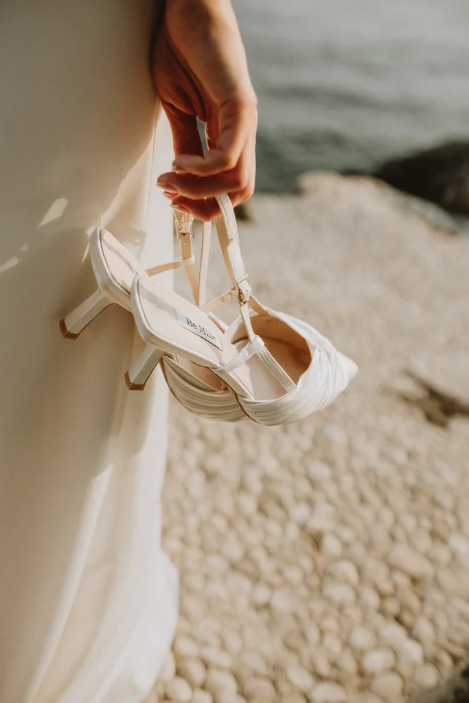 bride holding her wedding shoes